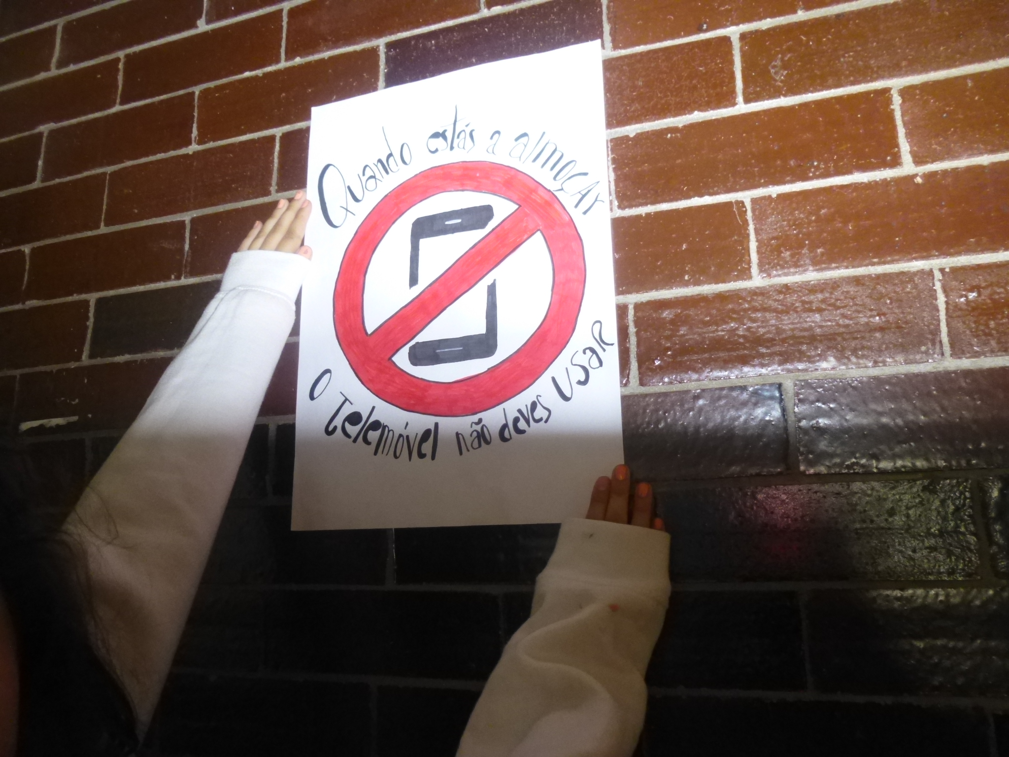Colocação do aviso elaborado pelos alunos na cantina da escola.